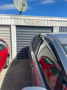 a car parked in front of a garage at One bedroom entire unit in Christchurch