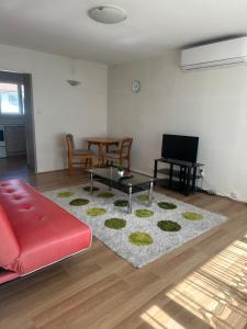 a living room with a red couch and a table at One bedroom entire unit in Christchurch