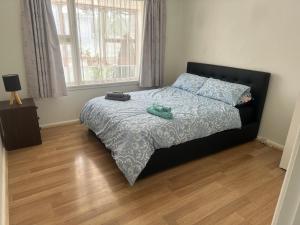 a bedroom with a bed with a black headboard at One bedroom entire unit in Christchurch