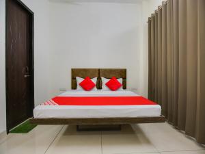 a bedroom with a bed with red pillows at Super OYO Hotel Comfort Regency in Ludhiana