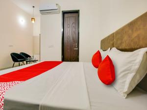 a bedroom with a bed with red and white pillows at Super OYO Hotel Comfort Regency in Ludhiana