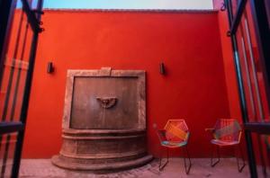 サンミゲル・デ・アジェンデにあるCasa Allegriaの赤い壁(椅子2脚、暖炉付)