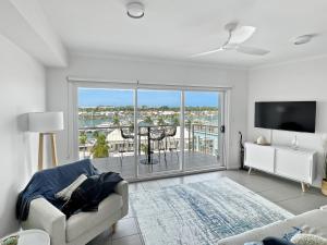 a living room with a couch and a large window at Welcome Homestay Bayside in Larrakeyah