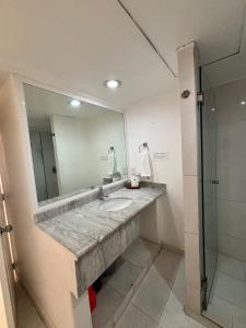 uma casa de banho com um lavatório e um espelho em ENNA INN IXTAPA HABITACIóN VISTA AL MAR em Ixtapa