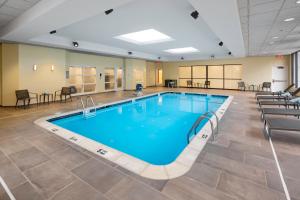 a swimming pool in a gym with chairs and tables at Courtyard Shelton in Shelton