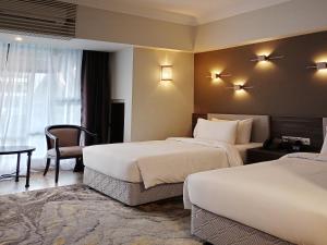 um quarto de hotel com duas camas e uma mesa em Bertam Resort,Penang em Kepala Batas