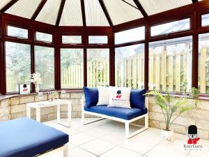 a gazebo with a blue chair in a room with windows at KOZYGURU WORSLEY 4BR 11 GUESTS SPACIOUS HOME UMWO029 in Worsley