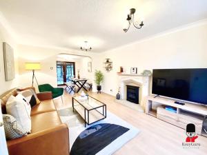 a living room with a large flat screen tv at KOZYGURU WORSLEY 4BR 11 GUESTS SPACIOUS HOME UMWO029 in Worsley