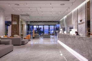 a lobby of a hotel with a person sitting at a counter at Balcony Seaside Sriracha Hotel & Serviced Apartments in Si Racha