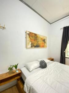 巴東的住宿－LORENT HOSTEL Nipah，一间卧室设有两张床,墙上挂着一幅画
