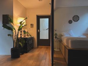 een slaapkamer met een bed en een plant naast een deur bij Korean Traditional terrace House Paradise Shopping Center in Seoul