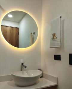 a white bathroom with a sink and a mirror at Zamá Room Hotel in Medellín