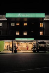 una tienda frente a un edificio por la noche en Deep Forest Inn en Fenchihu