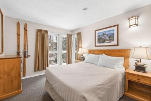 a bedroom with a bed and a window at Tantalus Resort Lodge in Whistler