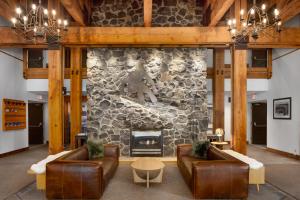 a living room with couches and a stone fireplace at Tantalus Resort Lodge in Whistler