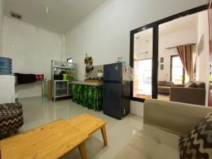 a living room with a couch and a refrigerator at Villa Harga Terjangkau di Malang in Malang