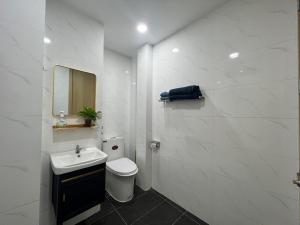 a white bathroom with a toilet and a sink at Private Homestay District 1, Tan Ðinh Ward, HCM City in Ho Chi Minh City