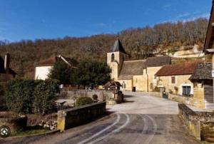 eine Straße in einem kleinen Dorf mit einer Kirche in der Unterkunft Gîte : La Petite Grange in Valojoulx