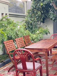 uma mesa de madeira e quatro cadeiras à volta de uma mesa de madeira em Woodland Cottage em Mwanza