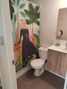 a bathroom with a toilet and a shower curtain at Hermoso y soleado departamento a pasos de casino Marina del Sol in Talcahuano