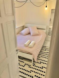 um pequeno quarto com uma cama com duas almofadas em The Loft - Bright apartment centre St Ives sleep 4 em St. Ives