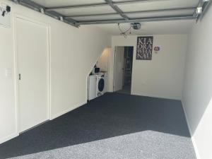 una stanza vuota con pareti bianche e una porta di Auckland CBD, Parnell Ensuite+Patio+Secluded Garage ad Auckland