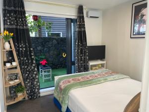 um quarto com uma cama e uma janela em Auckland CBD, Parnell Ensuite+Patio+Secluded Garage em Auckland