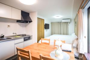 a kitchen and dining room with a table and a room with a bed at TuTuLu302 in Osaka