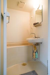 La salle de bains est pourvue d'un lavabo et d'une baignoire. dans l'établissement TuTuLu302, à Osaka