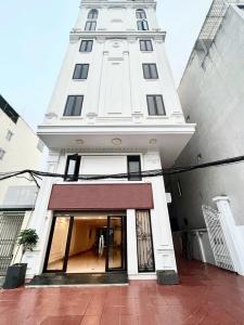 a tall white building with a door in front of it at IVY Homestay in Hai Phong
