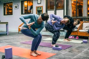 um grupo de pessoas a fazer yoga numa sala em Mountain Lodges of Nepal - Thame em Thāmi