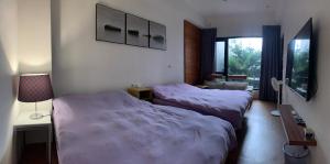 una camera con due letti, una lampada e una finestra di 幸福客棧 a Ho-mei