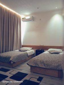 een slaapkamer met 2 bedden en een raam bij Maryam hotel in Samarkand