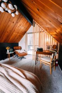1 dormitorio con cama, escritorio y silla en Mid-Century Cabin Perfect for Romantic Getaway, en Running Springs
