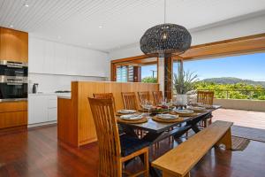una cucina e una sala da pranzo con tavolo e sedie di Sundecks a Emerald Beach