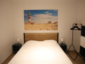 ein Schlafzimmer mit einem Bett und einem Leuchtturm an der Wand in der Unterkunft Riva Bella 102 right on the beach in Nieuwpoort