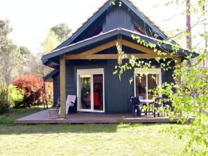 Casa azul con porche con mesa y sillas en Holiday home for 6 people, en Lacanau