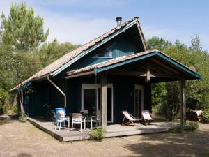 una casa azul con sillas y mesa en Holiday home for 6 people, en Lacanau