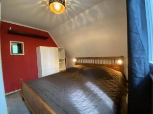Cama en habitación con pared roja en Holiday home Seehütte, en Kleinsaubernitz