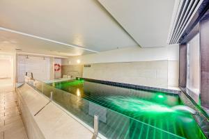 a swimming pool in a building with green illumination at St Falls West 202 in Falls Creek