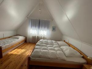2 letti in una camera mansardata con finestra di Holiday home Watersnip 5 a Lemmer