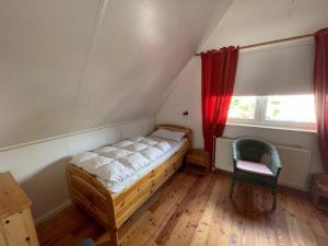 ein Schlafzimmer mit einem Bett, einem Fenster und einem Stuhl in der Unterkunft Holiday home Watersnip 5 in Lemmer