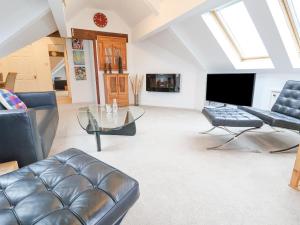 uma sala de estar com um sofá e uma mesa de vidro em Dragon's Den em Chester
