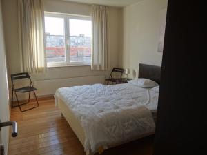 1 dormitorio con cama, ventana y silla en Ibiza 701 with frontal sea view, en Nieuwpoort