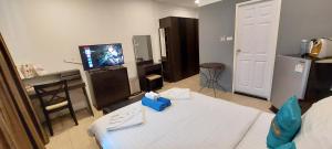 een woonkamer met een bed en een televisie bij Cafe de Paris in Patong Beach