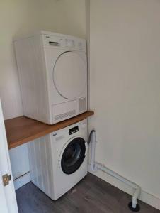 a microwave sitting on top of a washing machine at Completely Renovated House with 4 Double Beds in Halton