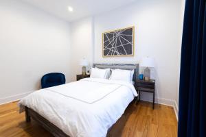 - une chambre avec un lit blanc et une chaise bleue dans l'établissement 7-3 2BR 1Bath in Prime Park Slope, à Brooklyn