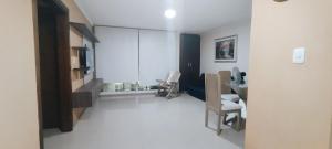 Habitación blanca con espejo y silla en Hermosa casa amoblada, en Barranquilla
