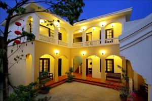 a large yellow and white building with lights at Hợp ý MAVINA cơ sở II in Hoi An