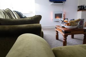 a living room with a couch and a table with a fireplace at 2 Riverside in Barnard Castle